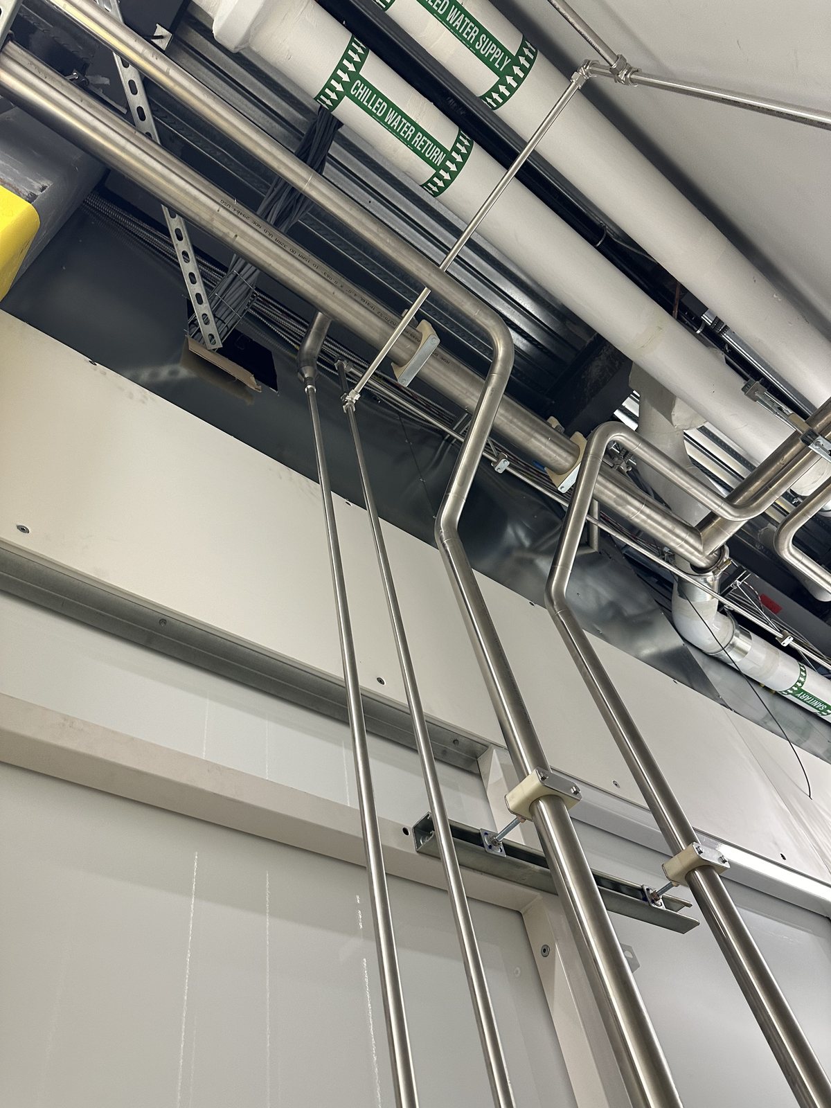 MJM stainless-steel pharmaceutical process piping routed through a clean production space